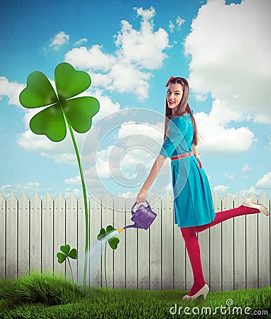 Woman watering a four leaf clover Stock Photo