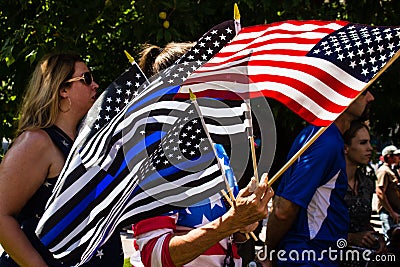 A Woman Waves Thin Blue Line and American Flags at a Conservative Rally Editorial Stock Photo