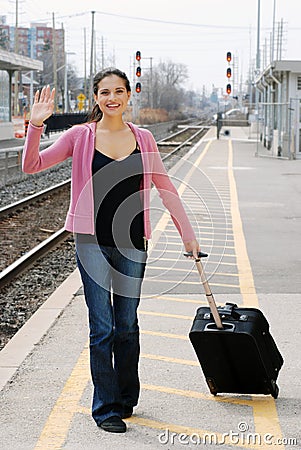 Woman waving at train station Stock Photo