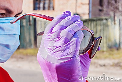 Woman wearing black sunglasses latex gloves and medical face mask Stock Photo