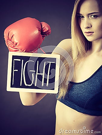 Woman wearing boxing glove holding fight sign Stock Photo