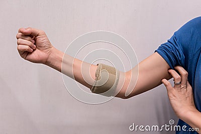 Woman wearing elbow brace to reduce pain Stock Photo