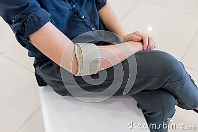 Woman wearing elbow brace to reduce pain Stock Photo