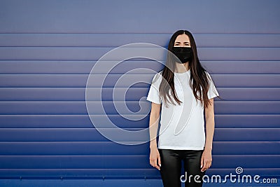 Woman wearing face mask because of Air pollution or virus epidemic in the city. Ðžn a blue background. Stock Photo