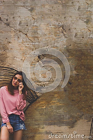 Woman wearing glasses standing beside old wall Stock Photo