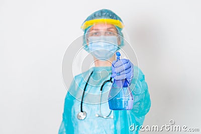 Woman wearing gloves, biohazard protective suit, face shield and mask with hand sanitizer bottle and disinfection gel. corona Stock Photo