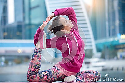 Woman wearing pink sportswear in One Legged King Pigeon pose Stock Photo