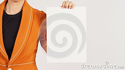 Woman is wearing a Radian Yellow suit and holding the blank A4 paper board on white background. Body part Stock Photo