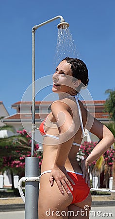 Woman wearing red bathing suit takes shower Stock Photo