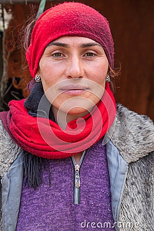 A woman wearing a red head scarf in the mountains of Tajikistan Editorial Stock Photo