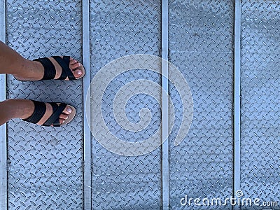 Woman wearing sandals on a metal ramp Stock Photo