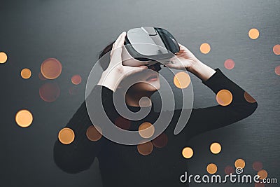 Woman wearing virtual reality goggles in modern coworking studio. Smartphone using with VR headset. Horizontal, blurred Stock Photo