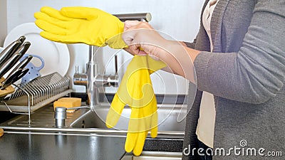 Young woman wearing yellow latex gloves on kitchen Stock Photo