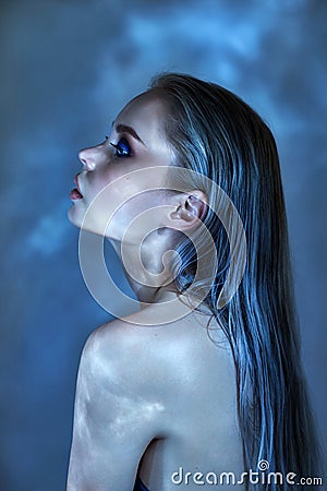 Woman with wet hair and bright makeup posing near the water, portrait. Glare from the water on the girl face, cosmetics moisturize Stock Photo