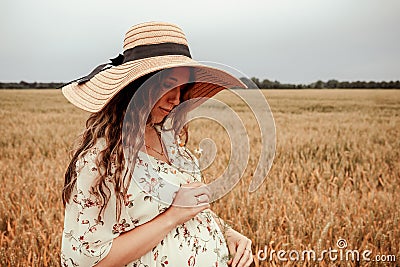 Woman wheat field nature. Happy young woman in sun hat in summer wheat field at sunset. Copy space, sunset, flare light Stock Photo