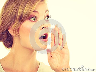 Woman whispering with hand close to mouth Stock Photo