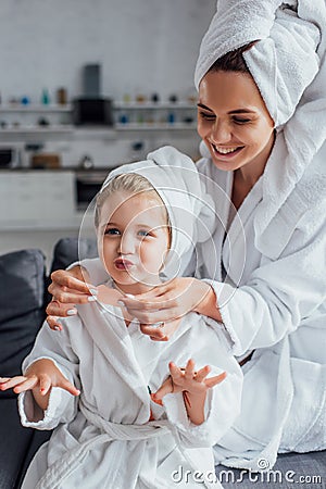 Woman in white bathrobe applying lips Stock Photo