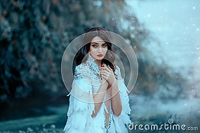 woman in a white cape with silver and feathers. The gentle snow queen. Stock Photo