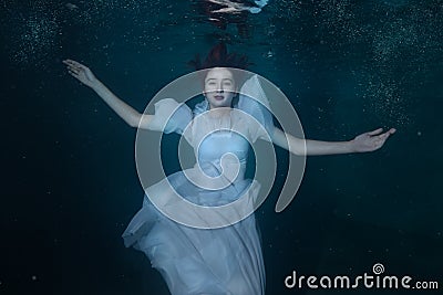 Woman in a white dress under water. Stock Photo