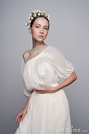 Woman in white greek dress with flowers on her head Stock Photo