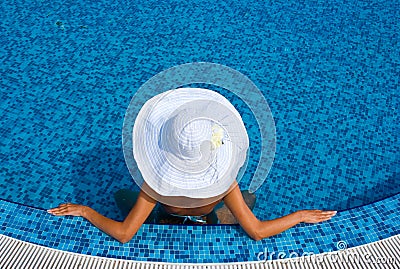 Woman with white hat in swimming pool Stock Photo