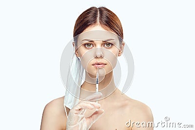 Woman on white isolated background holds a syringe, portrait Stock Photo