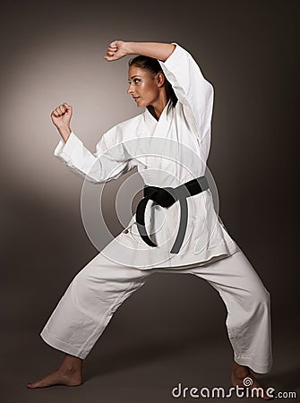 Woman in white kimono punch hard in the air - a karate martial art girl Stock Photo