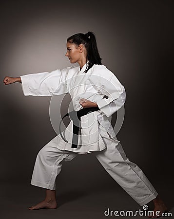 Woman in white kimono punch hard in the air - a karate martial art girl Stock Photo