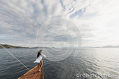 Woman in white shirt enjoying private tour on luxury wooden yacht. Ocean view Stock Photo