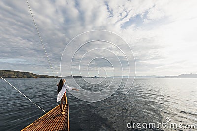 Woman in white shirt enjoying private tour on luxury wooden yacht. Ocean view Stock Photo