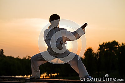 Woman in white suit make's taiji chuan - 4 Stock Photo