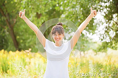 Woman in white t-shirt showing a thumbs up Stock Photo