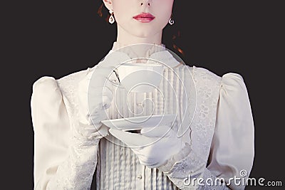 Woman in white victorian era clothes with cup of tea Stock Photo