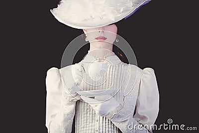 Woman in white Victorian era clothes with cup of tea Stock Photo