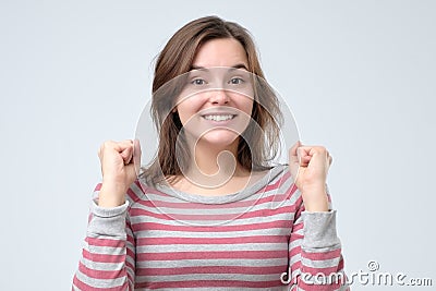 Woman winner raising arms, clenching fists, exclaiming with joy. Stock Photo