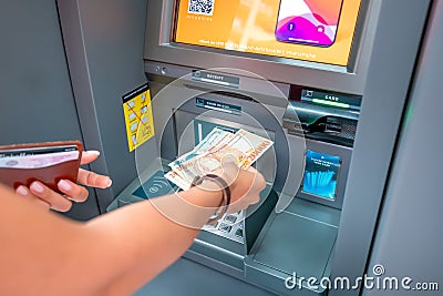 Woman withdraws Armenian drams cash from an ATM. The concept of the exchange rate of currencies and Editorial Stock Photo