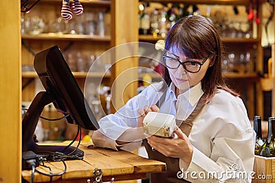 Woman worker manager of restaurant holding wireless banuov payment terminal Stock Photo