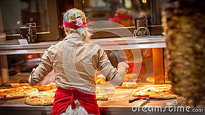 Woman worker selling pizza in fast food restaurant. Rear view Stock Photo