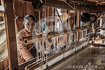 Woman worker weaves fabric in a weaving factory Editorial Stock Photo