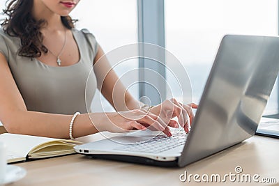 Woman working as copywriter at home. Close-up picture of female hands on pc keyboard in light office. Stock Photo