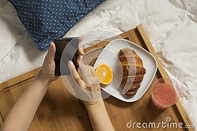 Woman working with her mobile and having breakfast Stock Photo