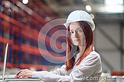 Woman working on laptop looking at camera Stock Photo