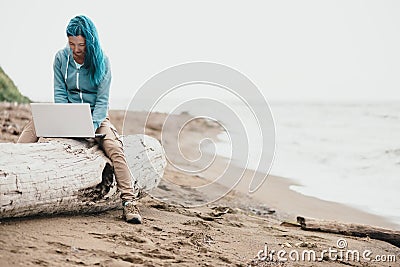 Woman working on laptop near the sea. Stock Photo