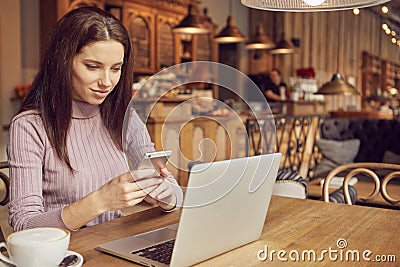 Woman works remotely online from cafe while quarantine coronavirus is in effect. Concept of checking mail, blogger, freelancer Stock Photo