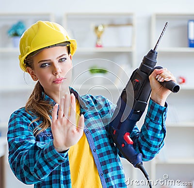 The woman in workshop with drilling drill Stock Photo