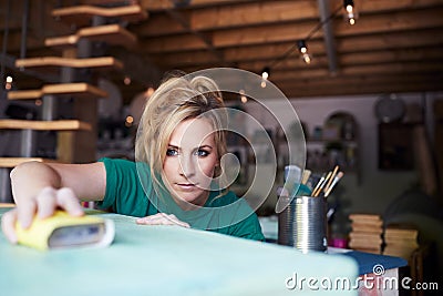 Woman In Workshop Upcycling And Working On Furniture With Sandpaper Stock Photo