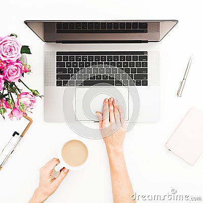 Woman workspace with female hands, laptop, pink roses bouquet, coffee mug, diary. Top view. Flat lay home office desk. Girl workin Stock Photo