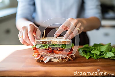 a woman wrapping a blt sandwich for lunch Stock Photo
