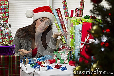 Woman wrapping Christmas presents, looking exhausted. Stock Photo