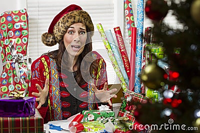 Woman wrapping Christmas presents, looking frustrated. Stock Photo